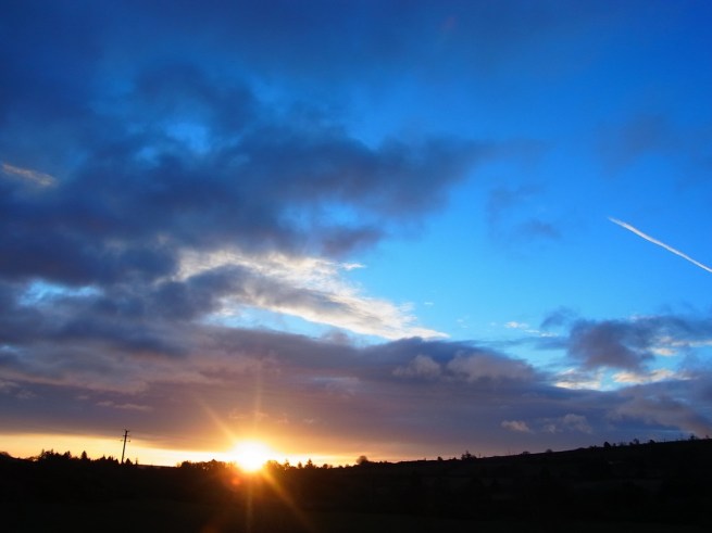 0322am0638 風が強いけど良い天気です（いまのところ）。６時３８分の朝焼け日の出ちゃん＠電信柱　ちょっと切れ目が入って「切られの与三郎」