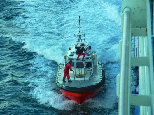 大きなフェリーに横づけしたと思ったら、上のほうに乗っていた人がフェリーのほうへ飛び移った！　C'est le guide qui arrive du port pour monter dans le ferry. Il a sauté vite fait et... 